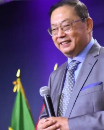 Pastor Daniel S. Chen speaking, holding a microphone